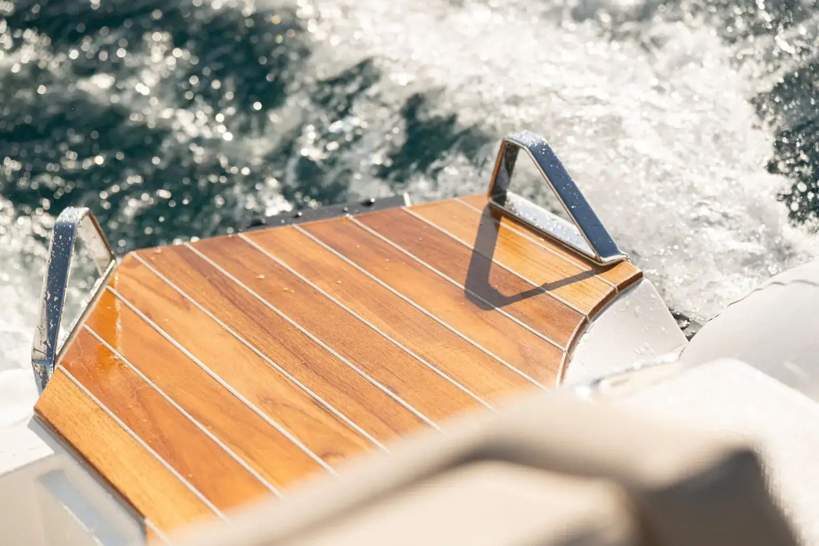 The teak bathing platform at the stern of the Technohull GT7 with stainless steel grab handles, photographed underway
