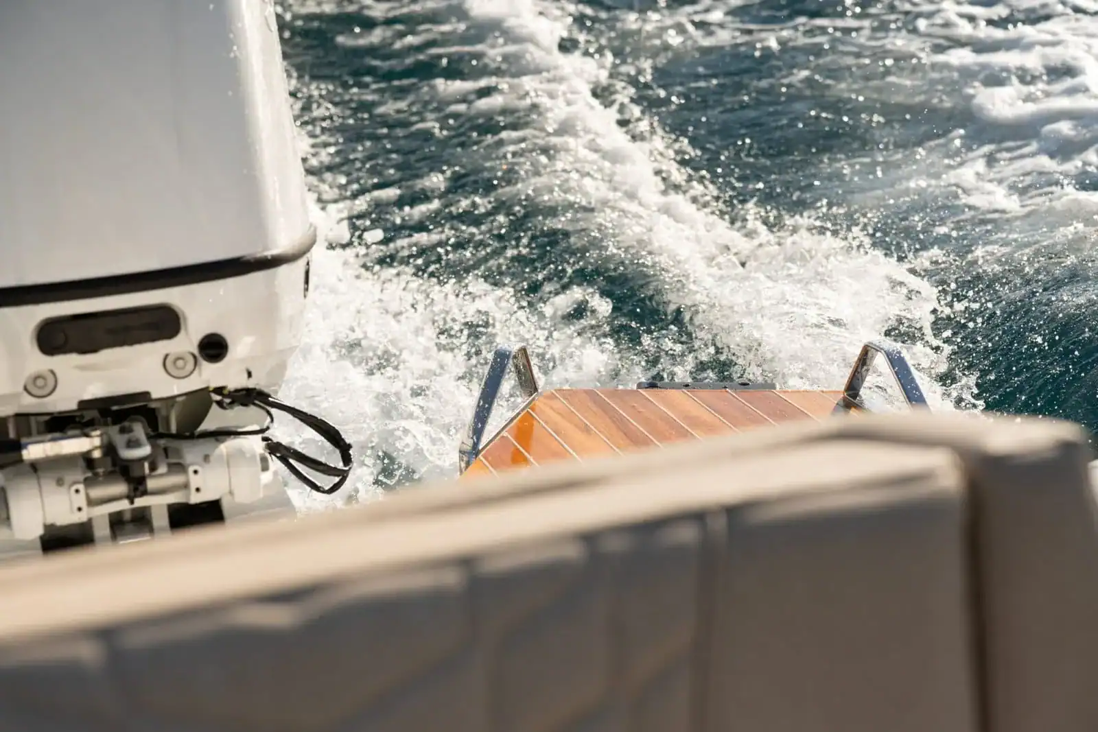 The transom of the Technohull GT7 underway, showing an engine, the teak platform and the back of the aft seat