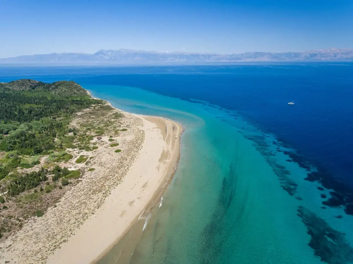 Porto Beach on Erikoussa, with sand and pine trees behind it